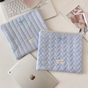 Detail of light blue striped quilted laptop sleeves with vertical and heart patterns