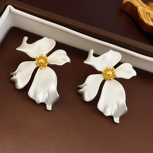 Close-up of matte silver flower earrings with golden core in a jewelry box