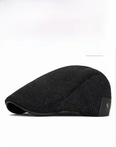 Close-up of black herringbone wool newsboy cap with leather patch and metal rivets