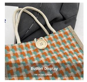 Detail show of woven linen tote bag featuring plaid pattern and wooden button closure