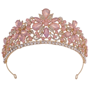 Detailed close-up of golden bridal tiara with pink crystals and floral alloy patterns