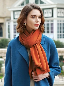 Close-up of vibrant orange pashmina shawl featuring delicate tassel fringe detail