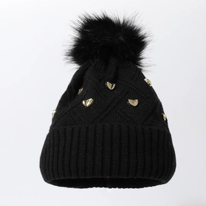 Bonnet en tricot noir avec clous en cœur dorés et grand pompon pour l'hiver au chaud