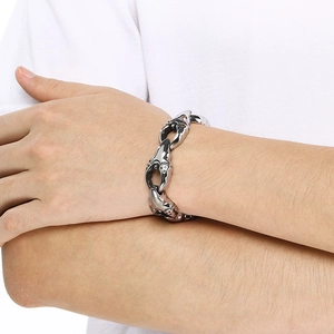 Detail of punk style stainless steel bracelet featuring heavy mechanical link chain design