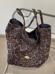 Large leopard print tote bag in brown tones with double handles and metal logo tag