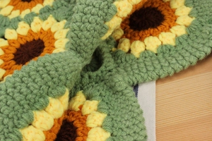 Macro shot of handcrafted crochet sunflower bag showing intricate yarn texture and petals