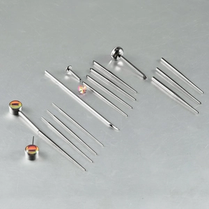 G23 titanium piercing tool kit with colorful body jewelry set on grey background