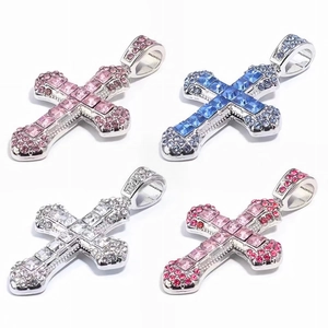 Detailed view of cross pendants set with pink, blue, and white sparkling crystals