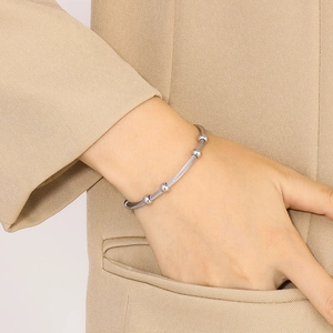 Close-up of a silver twisted cable bangle with polished beads on a female wrist