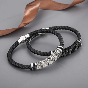 Détail d'un bracelet en cuir tressé avec chaînes en acier inoxydable et fermoir aimanté
