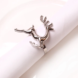 Detailed view of a single silver metal reindeer napkin ring on a white plate
