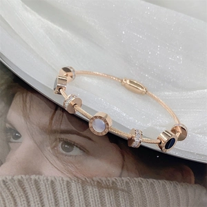 Rose gold stainless steel bangle featuring Roman numerals and sparkling diamond accents