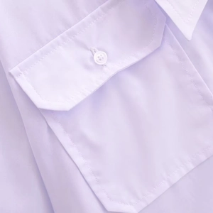 Close-up of light purple women blouse pocket showing fabric texture and white button