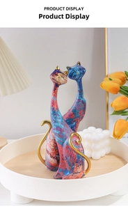 Detailed view of colorful graffiti resin cat statues with golden accents in home setting