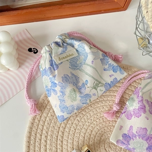 Dettaglio dei sacchetti floreali con coulisse, corde di cotone rosa ed etichetta laterale
