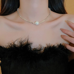Detailed view of large white pearl on silver woven chain necklace worn by model