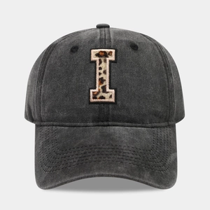 Close-up of vintage black baseball cap featuring leopard print letter I patch embroidery