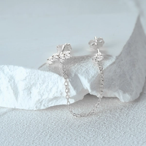 Macro shot of S925 silver chain link earrings with clear zircon stones on stones