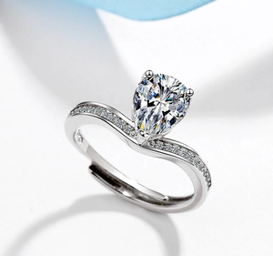 Macro shot of silver pear-cut zircon ring with pavé stones and adjustable open band