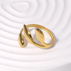 Macro shot of gold leaf stainless steel ring on minimalist white ripple display
