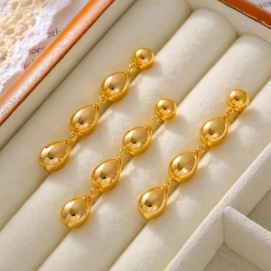 Elegant 18k gold plated triple teardrop tassel earrings displayed on a jewelry box