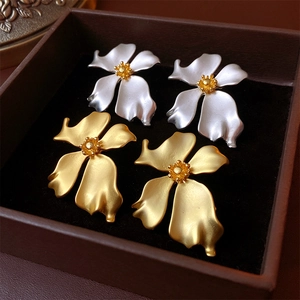 Macro view of vintage flower earrings in gold and silver finish inside a jewelry box