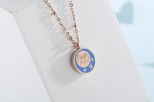 Macro view of Gemini rose gold necklace with light blue enamel coin pendant detail