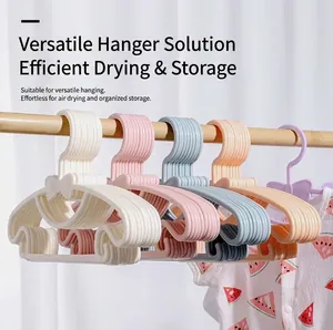 Detail of bow-knot baby clothes hangers in macaron colors hanging on a wooden rod