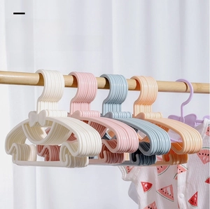 Detail of bow-knot baby clothes hangers in macaron colors hanging on a wooden rod