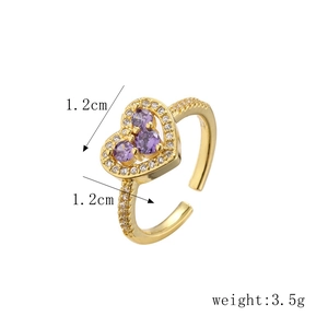 Dettaglio di un anello a cuore dorato con zircone viola e specifiche del peso