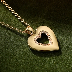 Fashion 18K gold plated heart pendant necklace with zircon stones on green felt surface