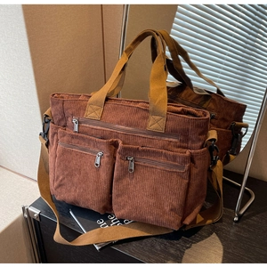 Detail view of brown corduroy tote bag with multiple pockets and mirror reflection