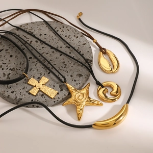 Bohemian gold starfish and shell pendant necklace set with black cord on stone