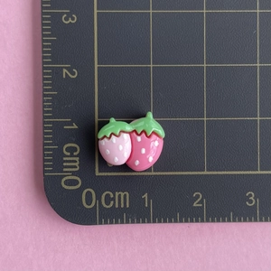Mini glossy strawberry resin charms showing 1.5cm size measurement on scale mat