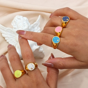 Detail of five 18k gold plated stainless steel rings with colorful enamel celestial motifs