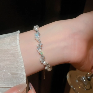 Detailed view of pearl and zircon bracelet with wavy design on a woman's wrist
