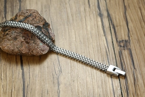 Detail of silver stainless steel dragon bone chain bracelet with square folding clasp