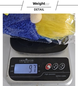 Detail view of sunflower gnome plush on an electronic scale showing a weight of 97g