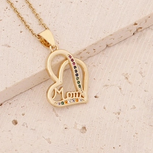Macro shot of 18K gold heart necklace for Mom with rainbow cubic zirconia on stone base
