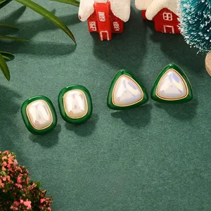 Close-up of vintage green enamel pearl earrings set on a festive Christmas themed backdrop