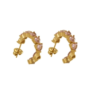 Detailed view of U-shaped gold earrings with heart-cut pink zircon stones and matte finish
