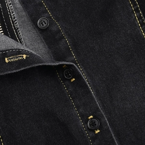 Makroaufnahme gelber Kontrastnähte und schwarzer Knopfdetails am Jeanskleid
