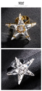 Detailed view of large star-shaped rhinestone rings in gold and silver finishes