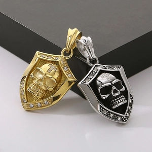 Close-up of gold and silver skull shield pendants with sparkling rhinestone borders