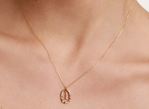 Close-up of gold S925 silver necklace with letter L pendant and colorful zircon frame
