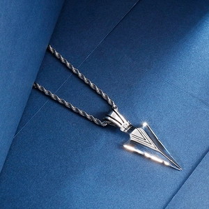 Macro detail of silver stainless steel arrowhead pendant on a twisted rope chain necklace