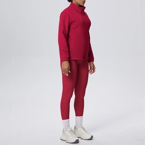 Dettaglio della giacca sportiva rossa con zip e dei leggings yoga coordinati a vita alta