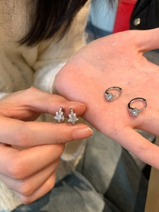Gros plan de créoles en forme d'étoile avec zircon argenté tenues à la main pour détails