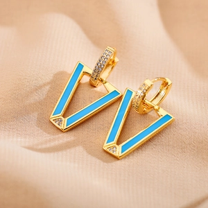 Detail of V-shaped gold earrings with light blue enamel and micro-pave crystals