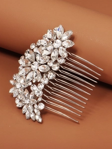 Macro shot of silver bridal hair comb with intricate rhinestones on a warm background